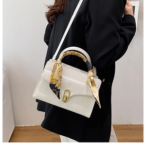 White handbag with silk scarf handle and gold twist lock detail shown on black blazer