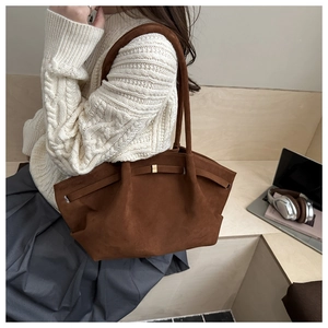 Close-up of caramel frosted tote bag with decorative gold buckle and strap detailing