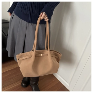 Close-up of a khaki bucket bag with gold buckle detail and matte leather finish