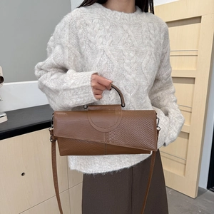Elegante bolso de mano marrón con textura de cocodrilo, costuras y asa metálica