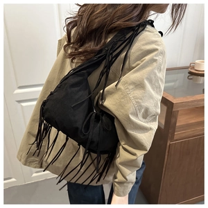 Detailed view of black tassel tote bag with long fringe and durable shoulder strap