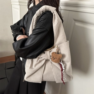 Sac bandoulière en velours côtelé beige avec nœud et ourson sur mannequin