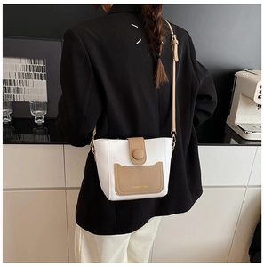 Detalle del bolso bandolera bicolor de moda en beige y caqui con correa ajustable