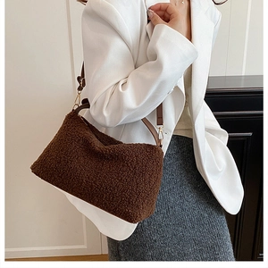 Detail of Boston bag featuring brown faux shearling and white leather paneling