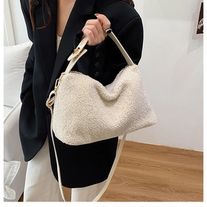 Detail of white faux fur crossbody bag with leather strap and gold metal buckle