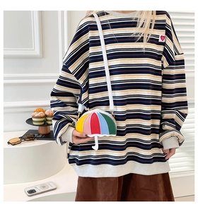 Close-up of creative rainbow patchwork umbrella-shaped crossbody bag with white strap