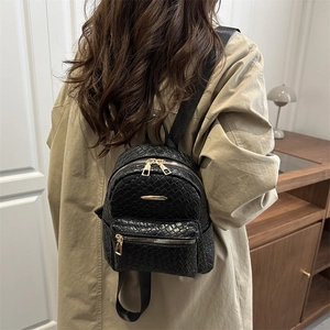 Sac à dos femme en cuir tressé noir avec fermetures dorées et style rétro élégant