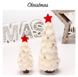 Detalle de árboles de Navidad creativos en fieltro con campanas doradas y base de madera