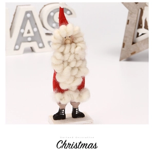 Primer plano de un Papá Noel de fieltro hecho a mano con barba suave y base de madera