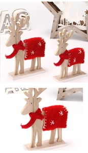 Detalle de renos decorativos de madera con bufandas de fieltro rojo y bordados