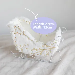 Detail of white plush Christmas sleigh decor with gold patterns and dimensions 27x12cm
