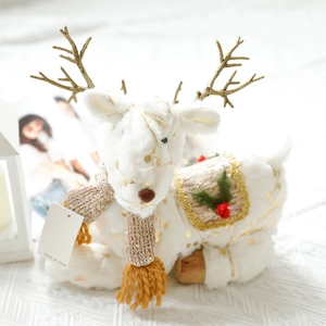 Detail of white plush reindeer ornament with golden antlers and a knit scarf decor