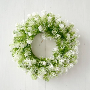 Close-up of artificial tulip wreath with white flowers on a white wooden door background