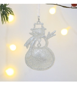 Close-up of a white glittery snowman ornament with a ribbon hanging on a Christmas tree