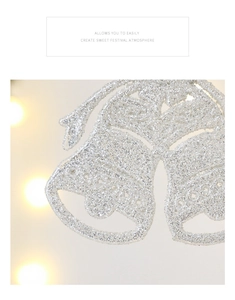 Macro detail of silver glitter Christmas bells with a ribbon bow and festive sparkles