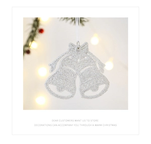 Close-up of glittery silver Christmas bells with bow detail and white ribbon hanger