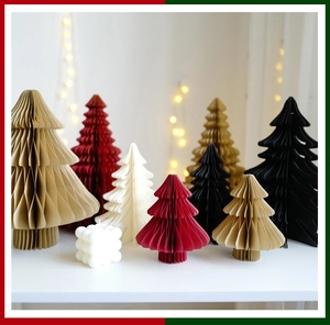 Détail de sapins de Noël en papier alvéolé coloré avec un ornement bougie bulle blanche