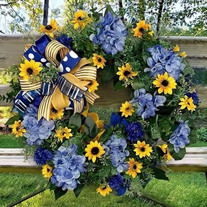 Artificial spring wreath with blue hydrangeas and yellow sunflowers on a wooden bench