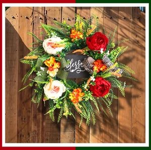 Detail of floral wreath with Blessed sign, leopard ribbons and lush green foliage