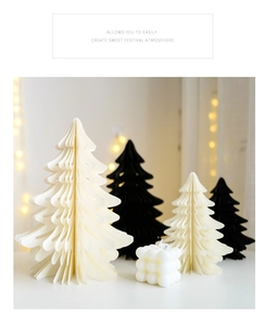 Gros plan d'arbres de Noël en papier alvéolé et bougie bulle avec lumières festives