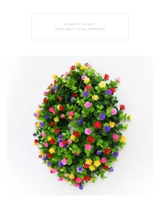 Détail d'une couronne d'eucalyptus artificielle avec feuilles vertes et fleurs multicolores