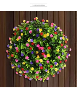 Gros plan d'une boule de fleurs artificielles colorées avec mini fleurs et feuilles vertes