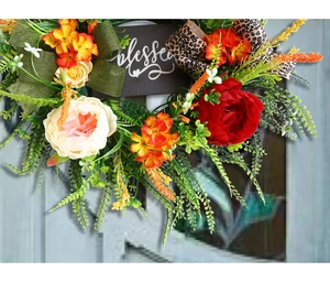 Macro detail of 'Blessed' floral wreath featuring red peonies and leopard print ribbon