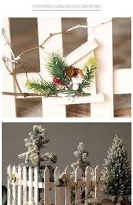 Détail de clôture en bois blanc avec aiguilles de pin, pommes de pin et baies rouges