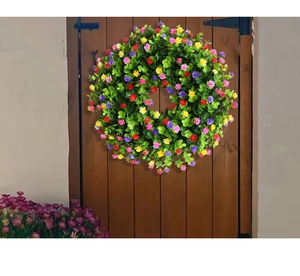 Vue détaillée d'une couronne d'eucalyptus artificielle multicolore sur une porte en bois