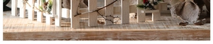 Détail de clôture en bois blanc avec branches de pin, pommes de pin et baies rouges