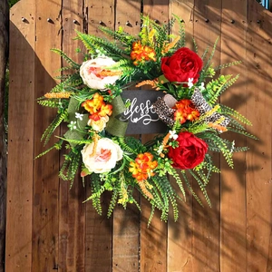 Artificial floral wreath with Blessed sign and leopard print bow on wooden door