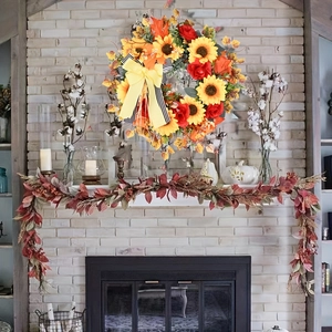 Wildflower autumn harvest wreath with sunflowers and maple leaves on a white brick fireplace