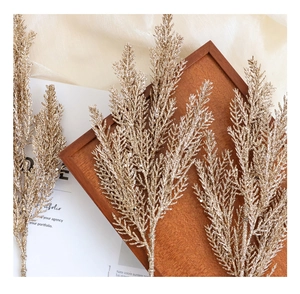 Detail of glittered golden pine branch on wooden tray for Christmas decoration