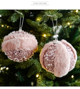 Dettaglio di palla di Natale rosa con pelliccia sintetica e perle su albero con luci