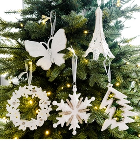 Detail van witte glitter kersthangers in de vorm van een vlinder, toren en sneeuwvlok