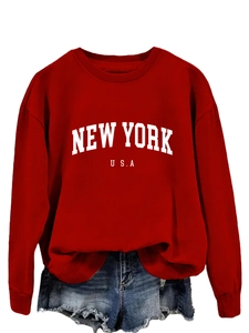 Dettaglio della felpa rossa girocollo con stampa New York USA bianca e shorts in denim