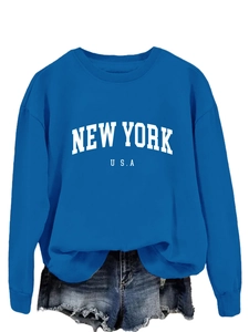 Dettaglio felpa blu con scritta New York e pantaloncini di denim con frange