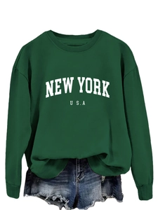 Dettaglio della stampa grafica New York USA su felpa verde scuro e shorts di jeans