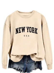 Dettaglio della stampa New York USA su felpa girocollo beige e pantaloncini denim