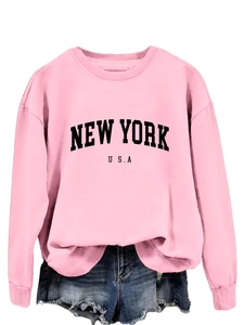 Dettaglio della felpa rosa chiaro con stampa New York USA e pantaloncini di jeans