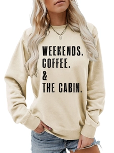 Close-up of beige crewneck sweatshirt with WEEKENDS COFFEE THE CABIN print detail