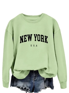 Dettaglio felpa verde chiaro con scritta New York USA e vestibilità comoda oversize