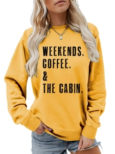 Close-up of Weekends Coffee and Cabin text print on mustard yellow crewneck sweatshirt