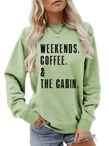 Close-up of WEEKENDS COFFEE THE CABIN print on a light green crewneck sweatshirt