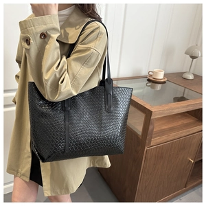 Gros plan sur la texture tressée noire du grand sac cabas en cuir pour femmes