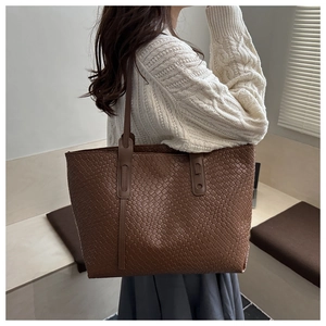Close-up of woven texture on a large brown tote bag with premium leather finish