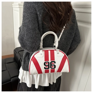 Detail of white bowling bag with red stripes and number 96 patch on grey sweater