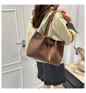 Dettaglio borsa tote marrone in pelle PU intrecciata con fibbia in metallo e tracolla