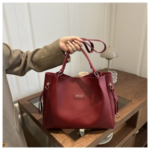 Detalle del bolso tote grande granate con asas dobles y textura de cuero sintético liso