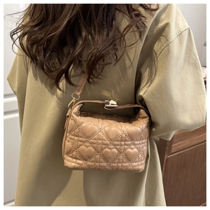 Detail of beige heart-quilted crossbody bag with metallic buckle and slim strap